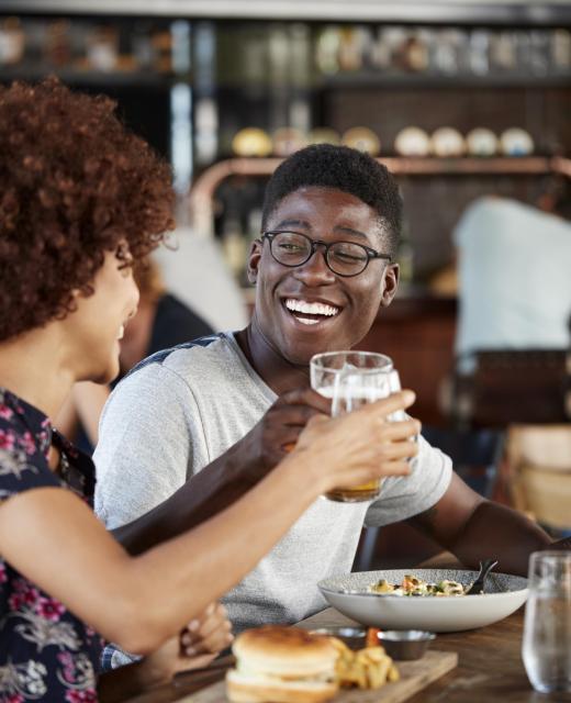 Couple On Date Meeting For Drinks And Food Making A Toast In Restaurant